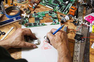 Josh A. Weston draws surrounded by fax machine parts.