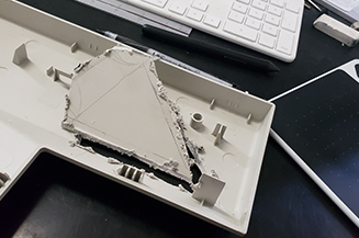 Fax machine part cut into triangle with rough edges.